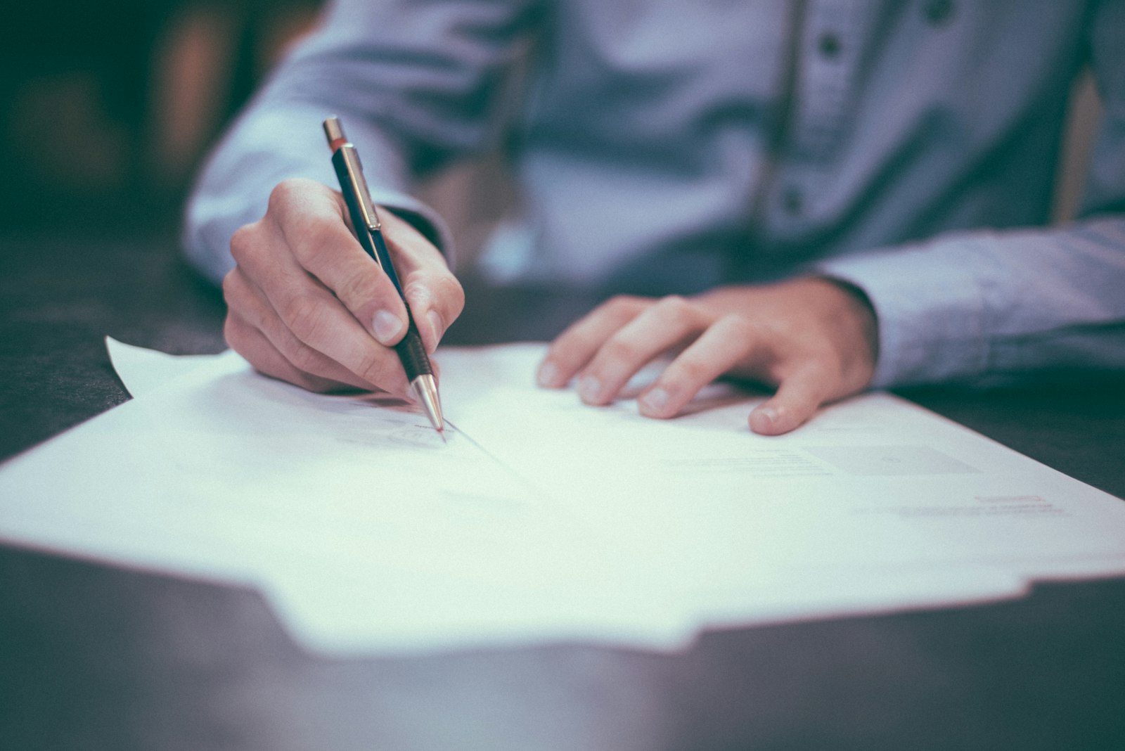 A Meridian Ledger accountant annotating a printed statement with a pen at a desk
