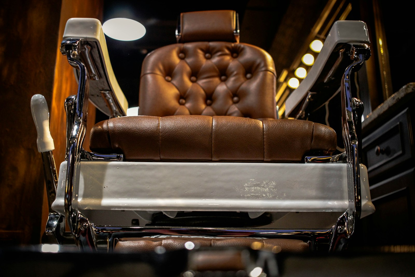 A vintage chrome-and-leather barber chair standing ready on the shop floor