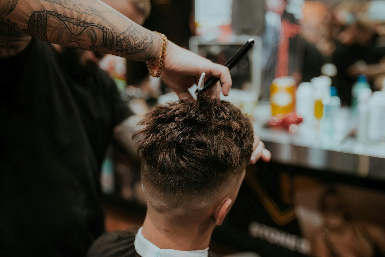 Barber Marco Reyes cutting a client's hair with comb and shears