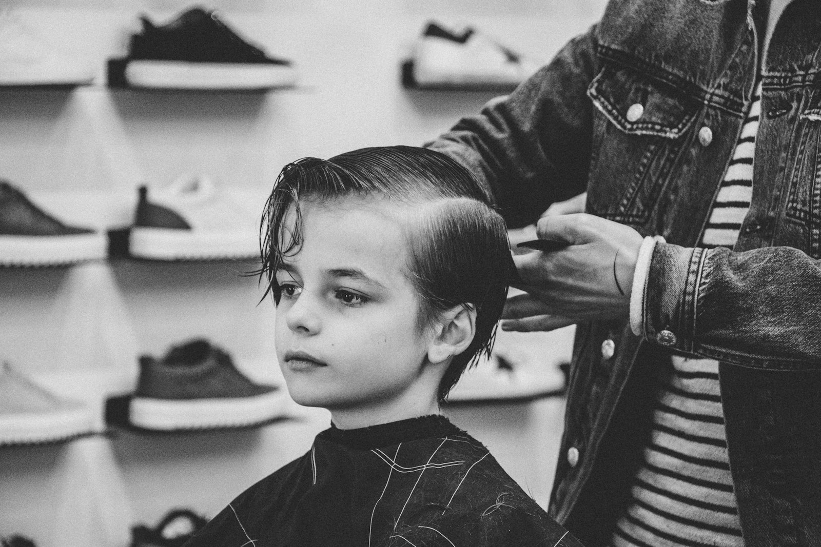 Young boy in the barber chair getting his hair combed and cut