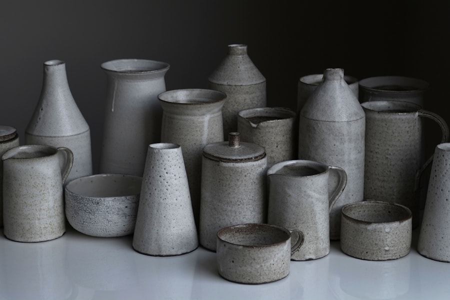 A grouped set of grey ash-glazed stoneware cups, bowls, jugs and lidded jars arranged together.