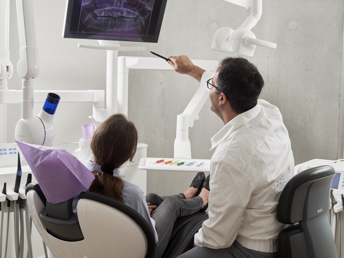 A dentist showing a patient her X-ray on the chairside screen during a consultation