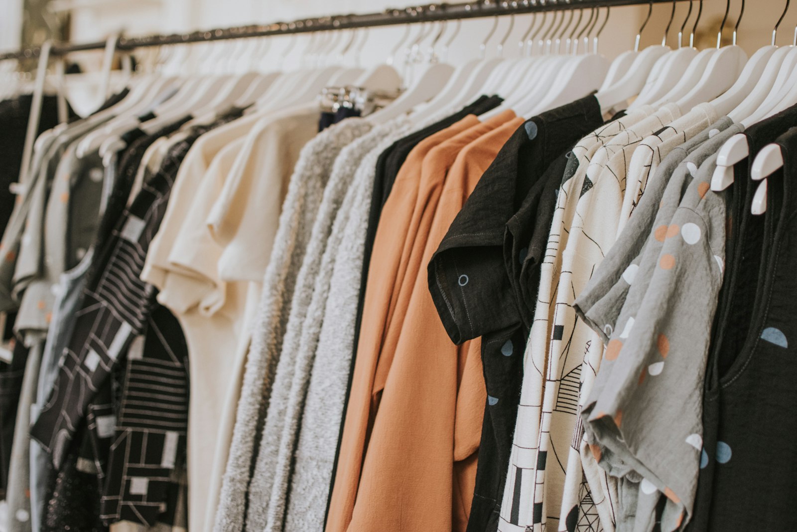 A rail of garments hanging in the ARQIVE studio, shot in close focus