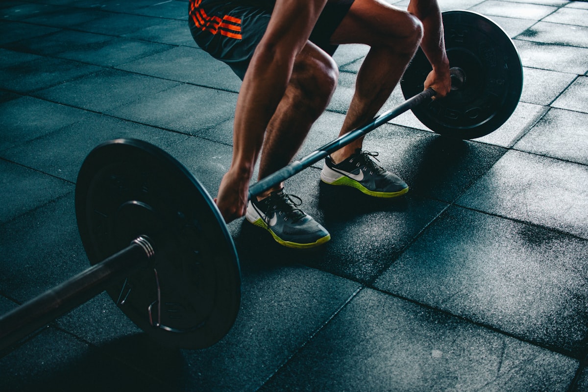 Athlete mid-effort holding dumbbells during a conditioning circuit