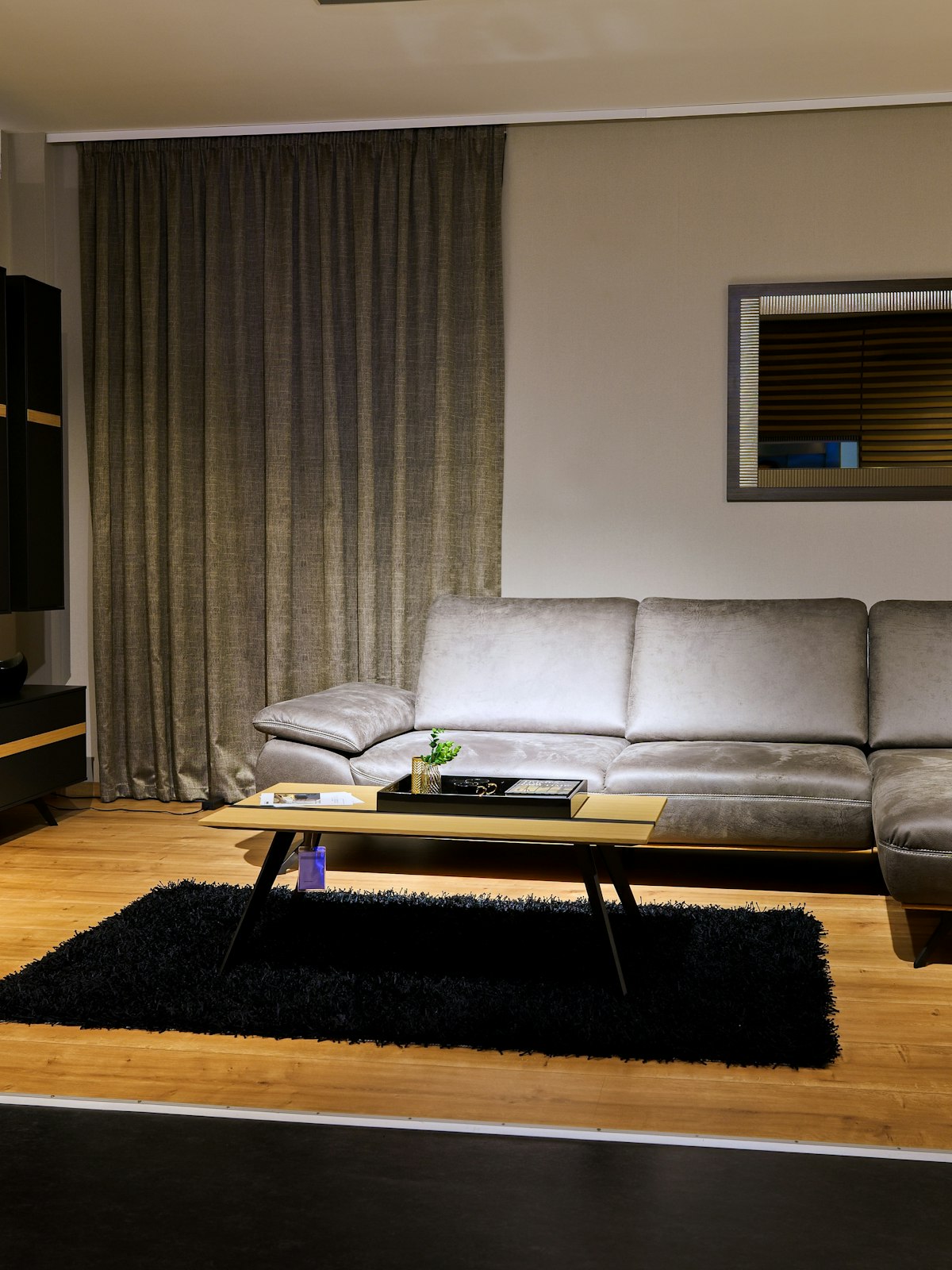Norra Living showroom floor: a grey modular sofa, an oak coffee table and a low sideboard on pale timber