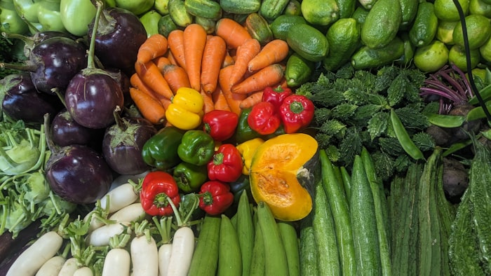 Aubergines, carrots, peppers, courgettes and leafy greens laid out fresh from the field