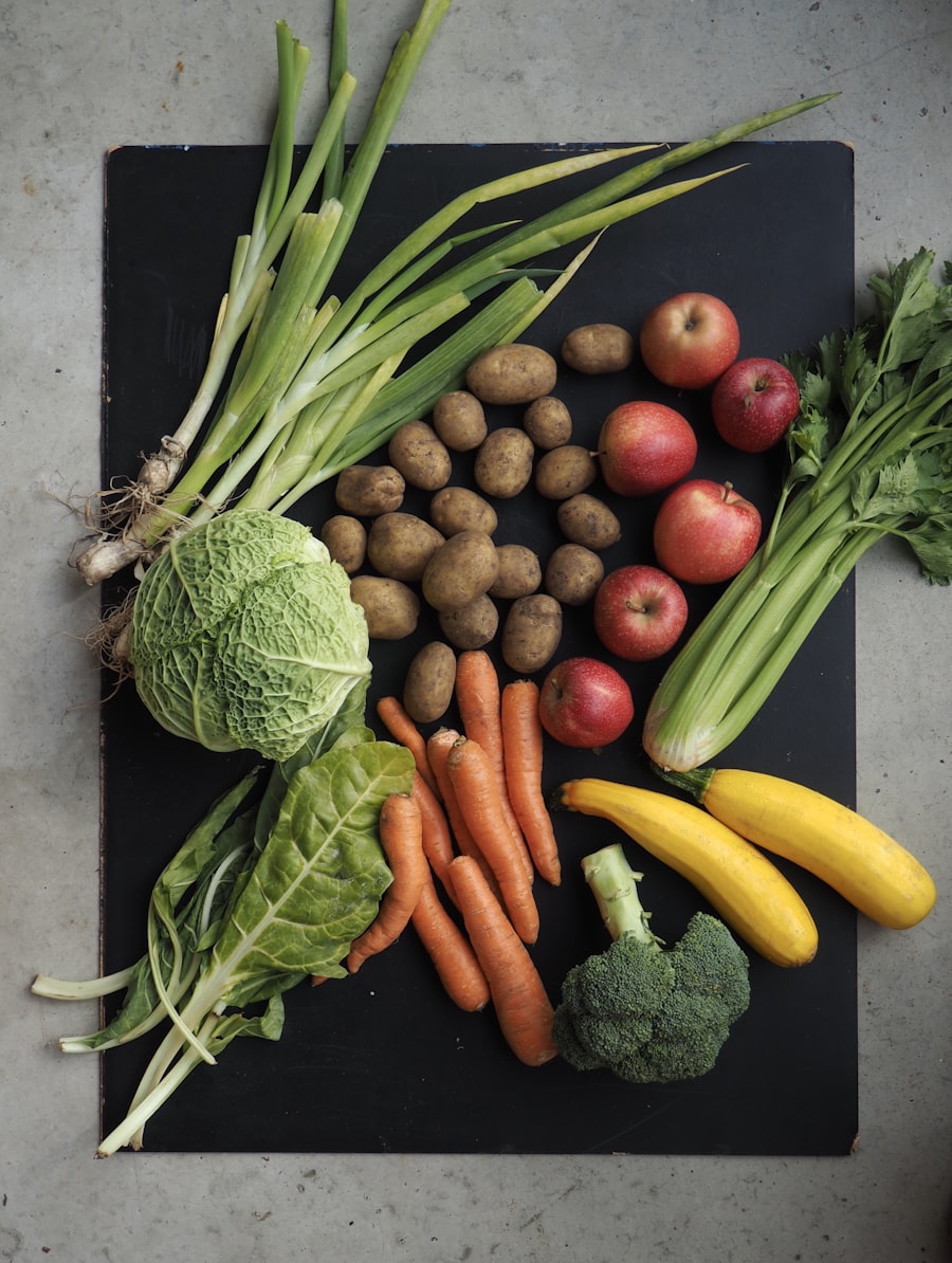 Savoy cabbage, leeks, potatoes, carrots, apples, celery, chard and courgettes laid out ready to be boxed