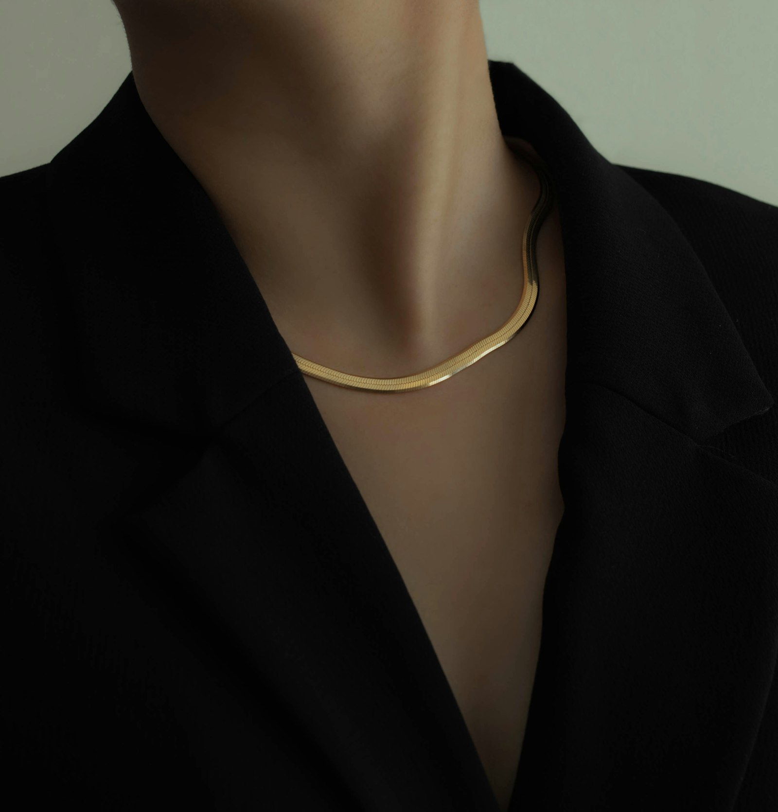 The Lisse herringbone necklace in 18k yellow gold, worn open-collar