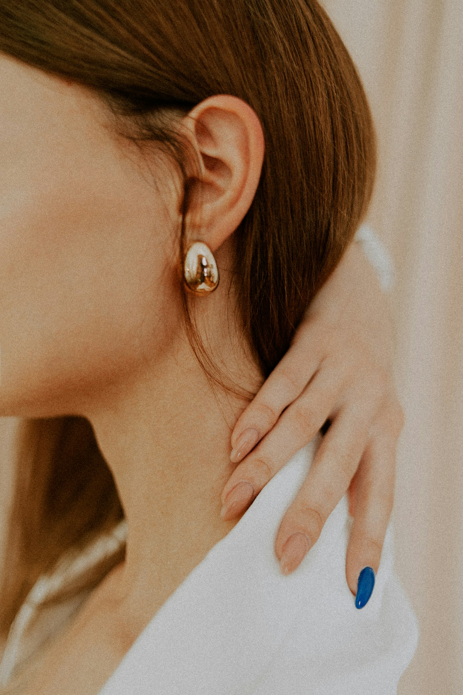 The Galet polished dome earring in 18k gold, worn close to the ear
