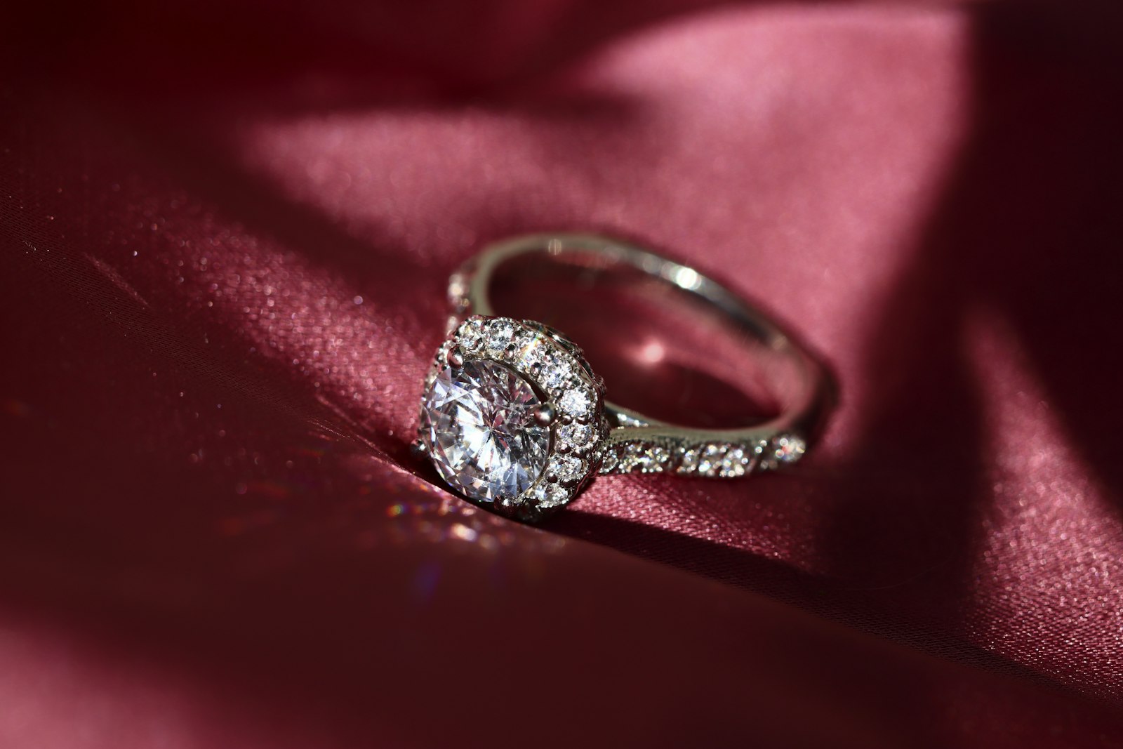 The Halo Brilliant engagement ring in 18k white gold on burgundy silk