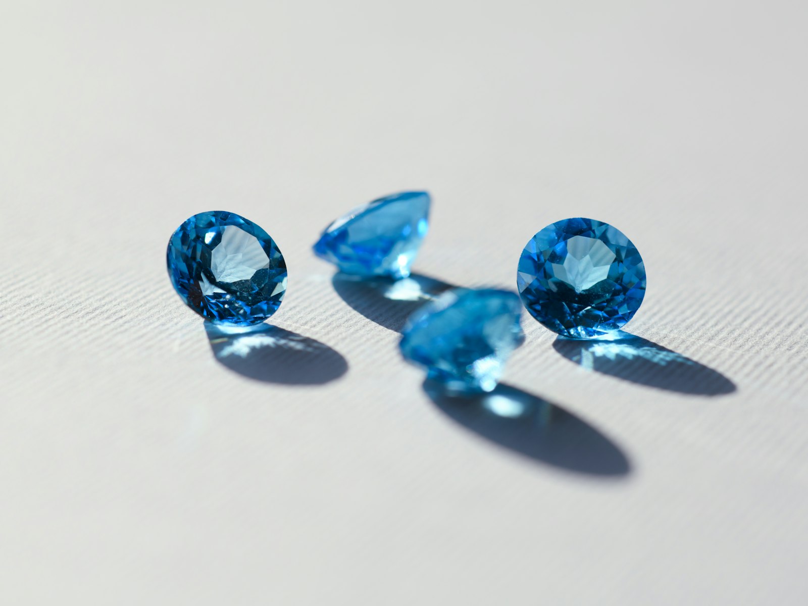 Four loose London-blue topaz stones cut for the Vigie collection