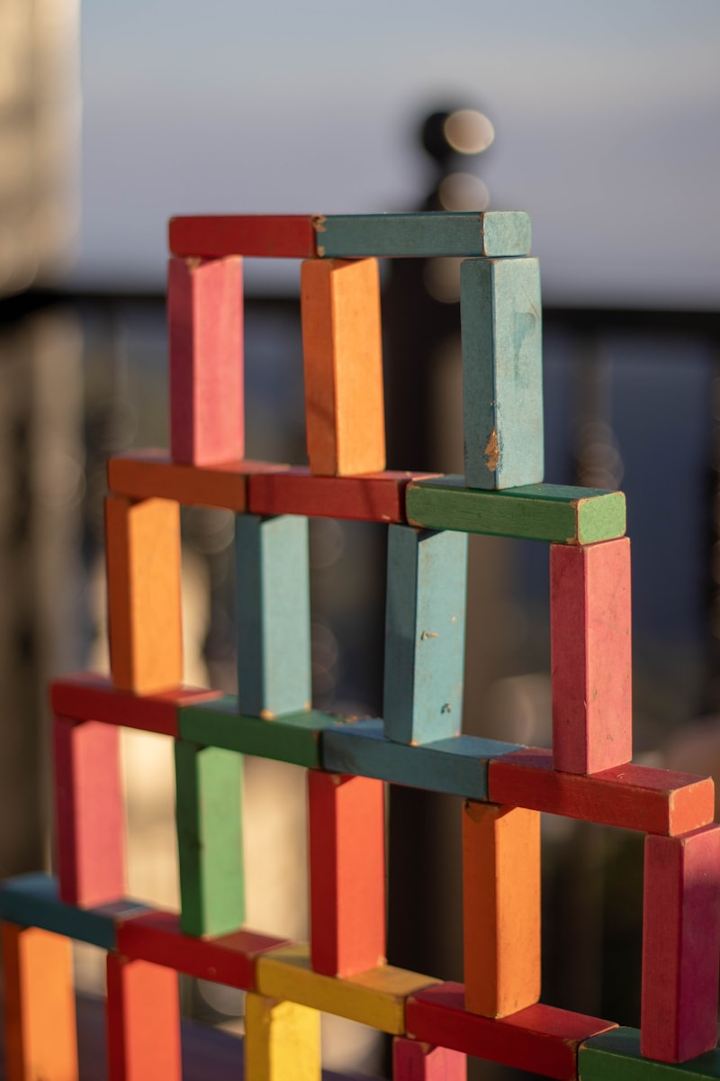 A tall lattice tower built from red, blue, green and orange painted wooden planks.