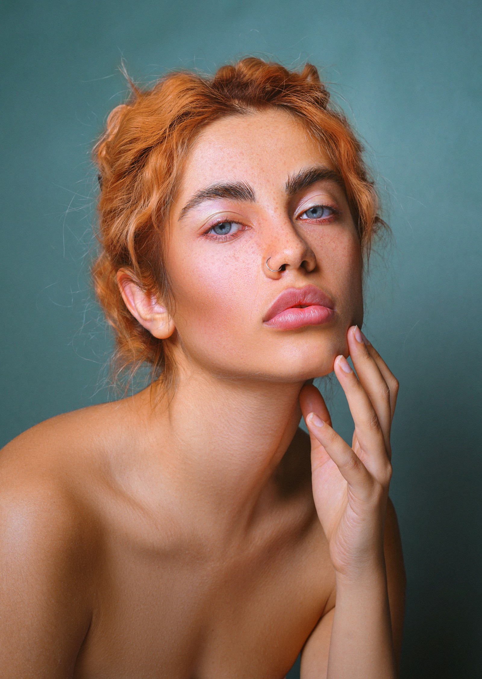 Case two, before state: portrait of a woman against a teal ground, shown in a cooler, lower-contrast grade.