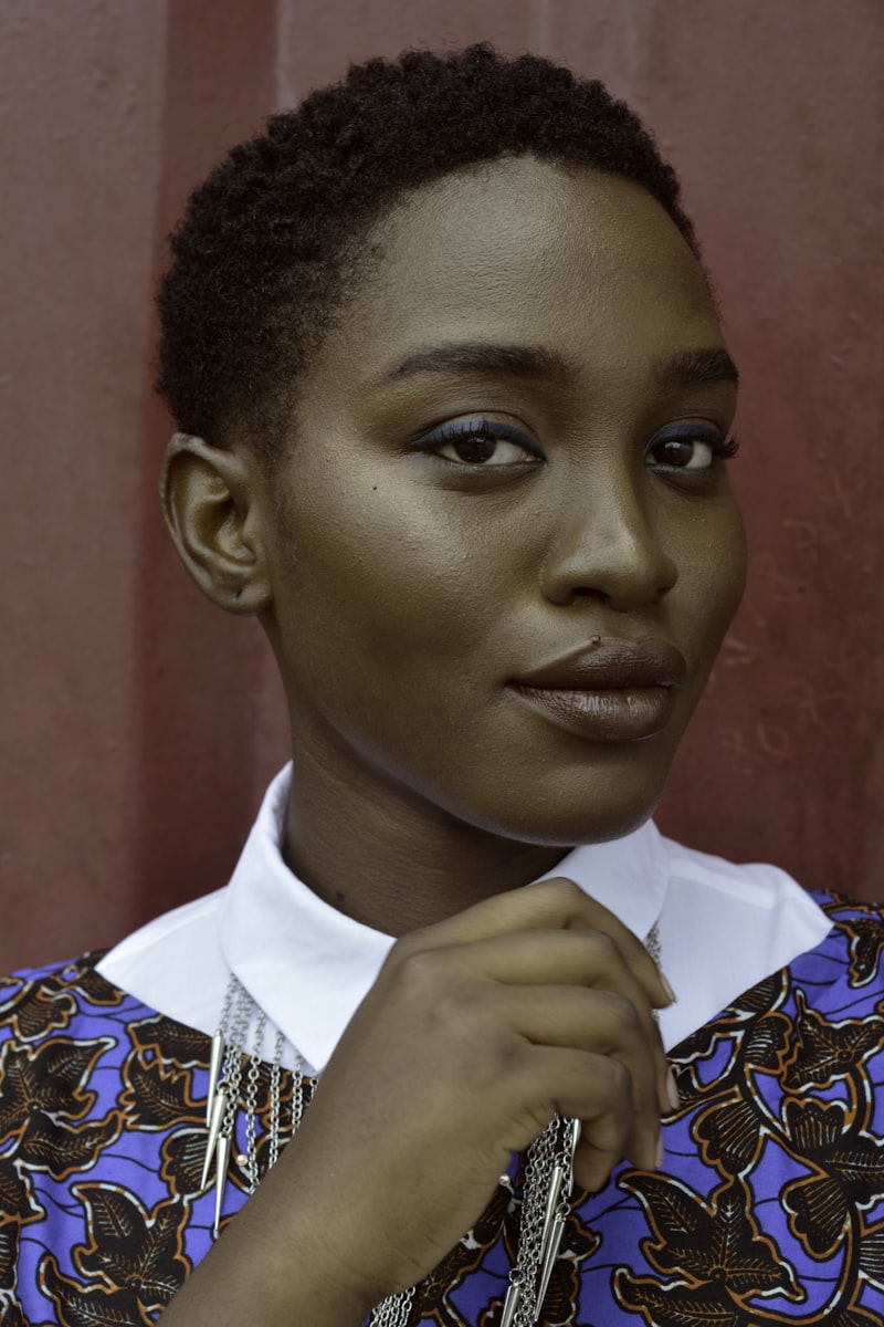 Portrait of Dr. Naomi Adeyemi, a poised therapist resting her hand near her chin