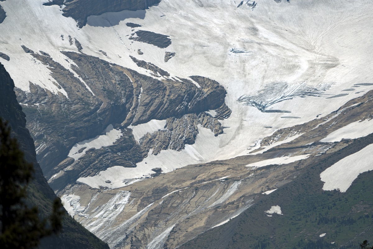 Glacier and exposed rock strata forming natural contour lines on a mountain face