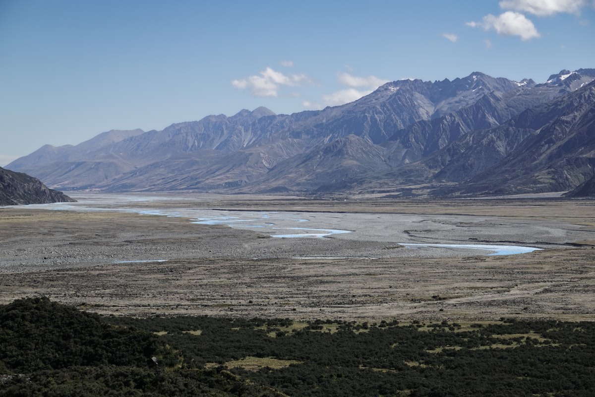 Braided glacial river running through a wide gravel valley below a mountain range