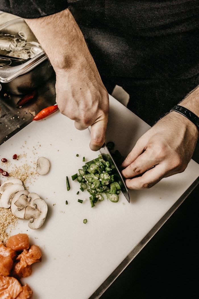 Chef's hands preparing mise en place at the board beside the hearth