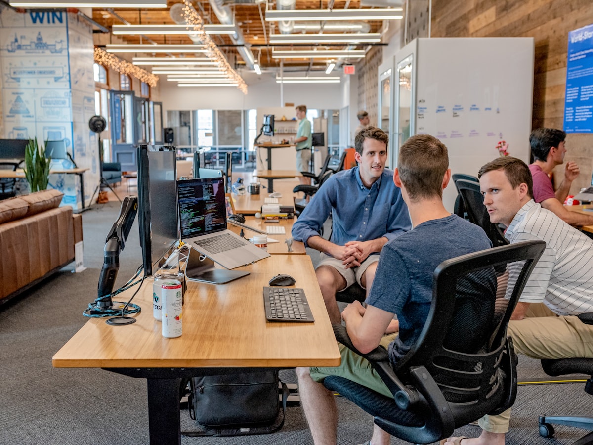 Flowdesk support engineers laughing while pairing at a shared desk