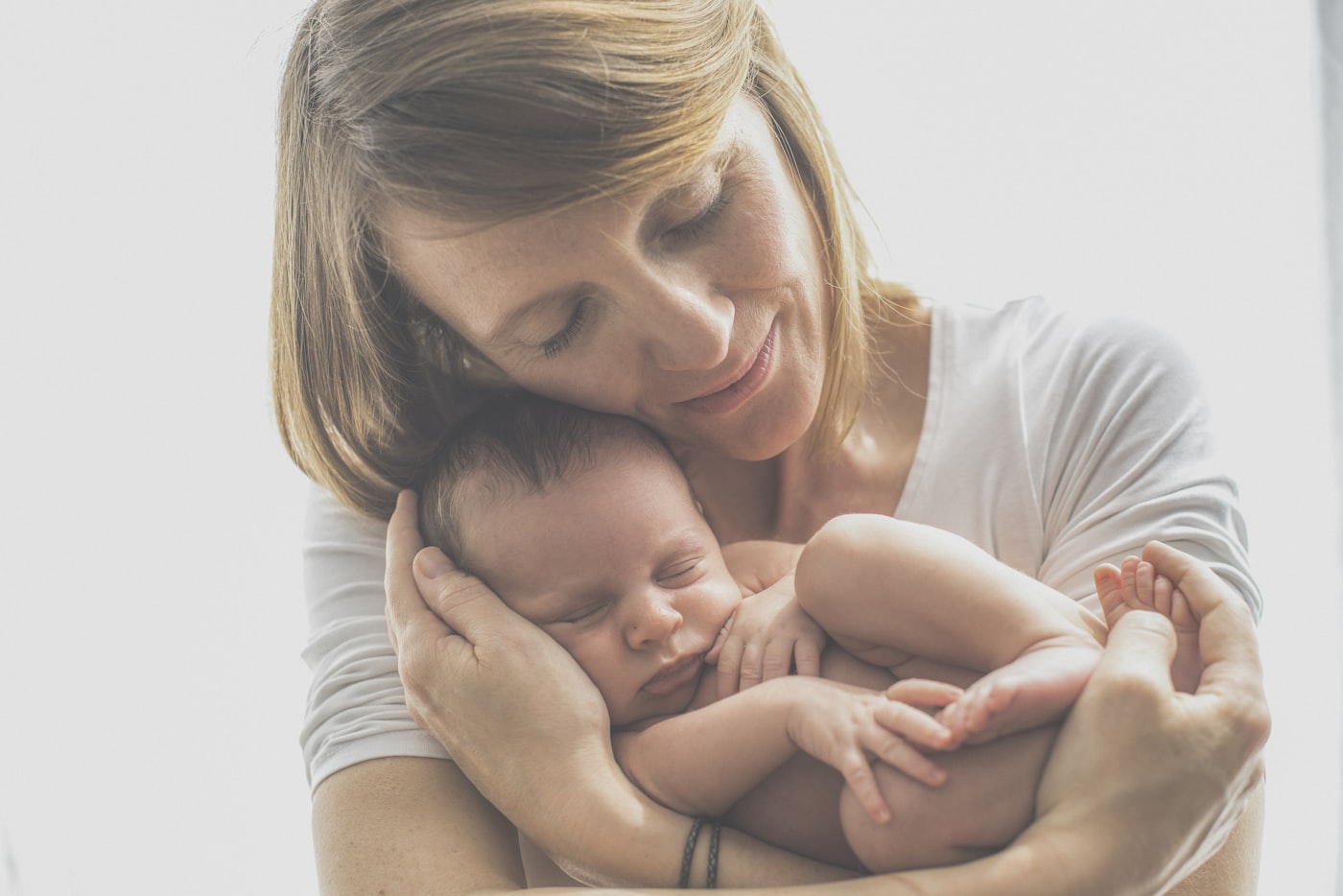 Mẹ mặc áo cotton mềm bế bé sơ sinh đang ngủ