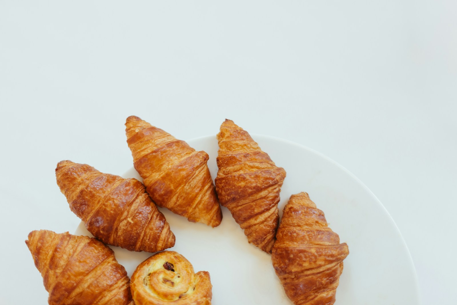 Đĩa bánh và đồ uống buổi sáng bày trên bàn sáng màu