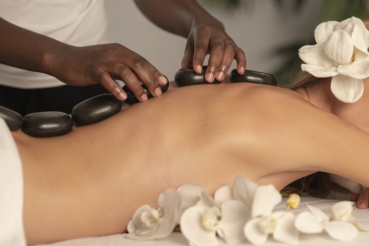 A therapist laying heated basalt stones along a guest's spine