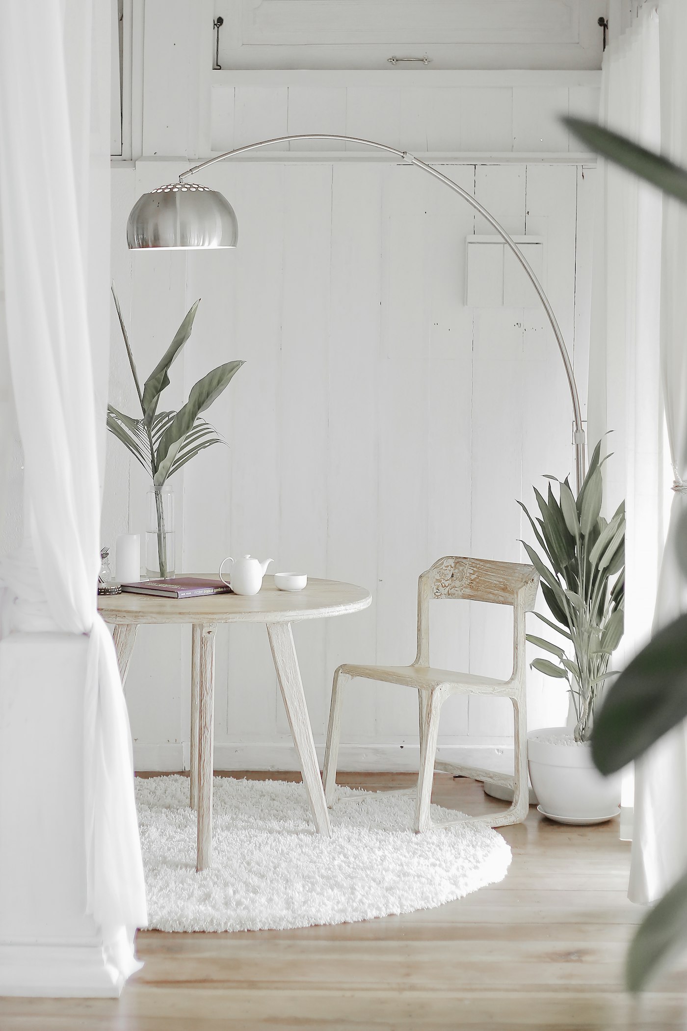 The Stillwater rest lounge: pale wood chair, linen curtains and potted greenery in soft daylight